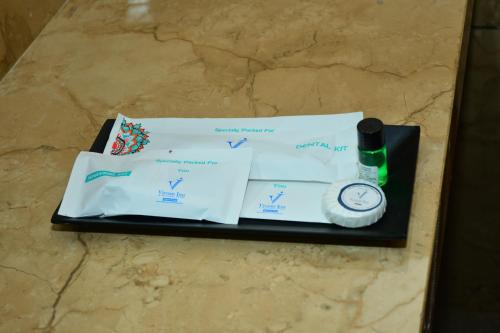 a tray with a watch and papers on a counter at Vivaan Inn in Vijayawāda
