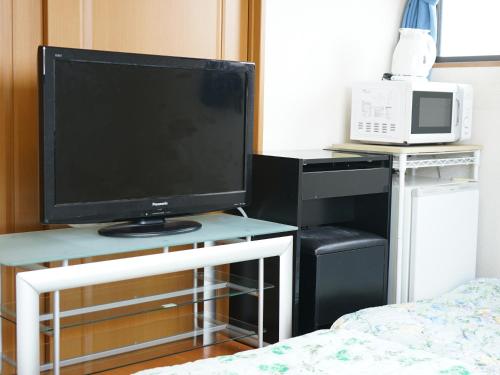 a television sitting on a desk in a bedroom at ECO inn in Inazawa