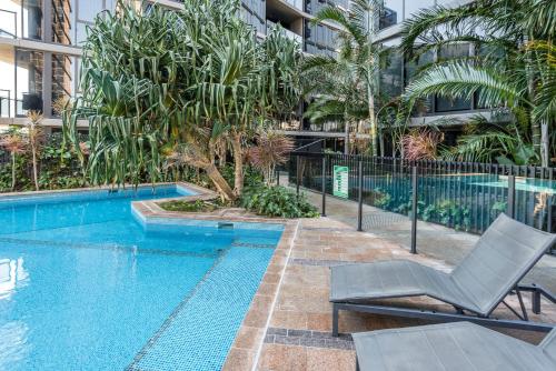 a swimming pool with a chair next to a building at Central Located Cozy Studio in South Brisbane in Brisbane