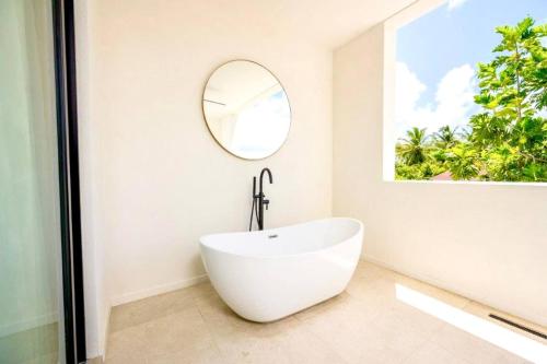 a white bath tub in a bathroom with a mirror at ZenBreak Azzurro 9, 2bd in Saint James