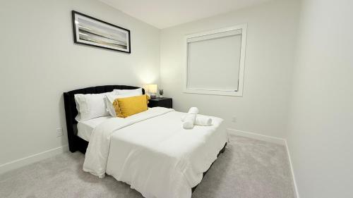 Un dormitorio blanco con dos camas y una ventana. en Casa Koko, en Calgary