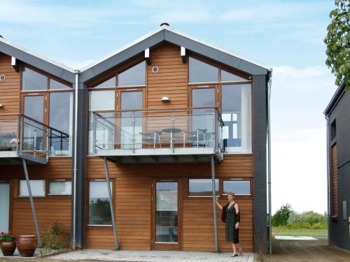 ボーゲンセにある6 person holiday home in Bogense-By Traumの家の前に女が立っている