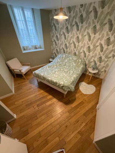 a small bedroom with a bed and a wooden floor at Résidence Galia in Sainte-Feyre