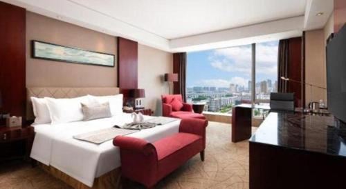 a hotel room with a large bed and a red chair at Wuhan Soluxe Hotel in Wuhan