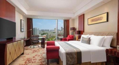 a hotel room with a bed and a large window at Wuhan Soluxe Hotel in Wuhan