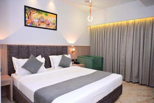 a bedroom with a large white bed in a room at Vivaan Inn in Vijayawāda