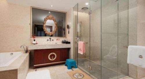 a bathroom with a shower and a sink and a mirror at Wuhan Soluxe Hotel in Wuhan