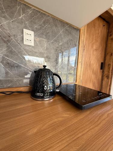 a black tea kettle sitting on top of a table at Refugio lliu lliu, eco suite in Huiscapi