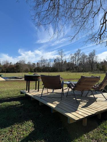 two chairs and a table on a wooden deck at Refugio lliu lliu, eco suite in Huiscapi
