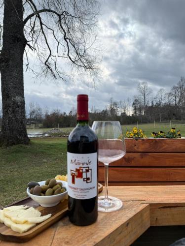 a bottle of wine and a glass on a table at Refugio lliu lliu, eco suite in Huiscapi