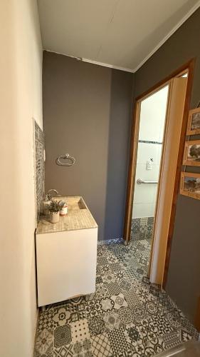 a bathroom with a sink and a tile floor at Casa en Roldán 2 habitaciones in Roldán