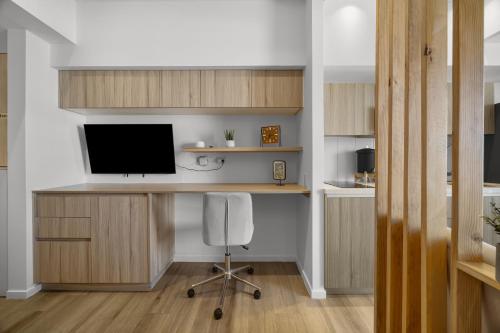 a room with a desk with a television and a chair at Panoramic Airport Views from 11th Floor Apartment in Guatemala