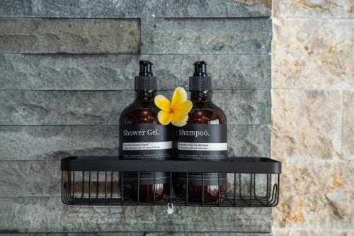 two bottles of vinegar and a flower on a shelf at Mahayani Ubud Villa in Tegalalang