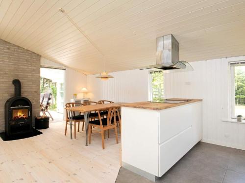 a kitchen and dining room with a table and a stove at 8 person holiday home in Hals in Hals