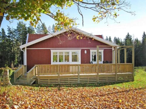 a red house with a large deck in front of it at 4 person holiday home in Brålanda-By Traum in Brålanda
