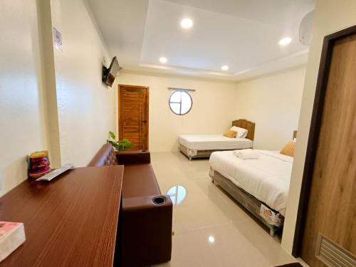 a hotel room with two beds and a desk and a desk at in love รีสอร์ท ผัง 3 เขาใหญ่ in Ban Nong Chaeng