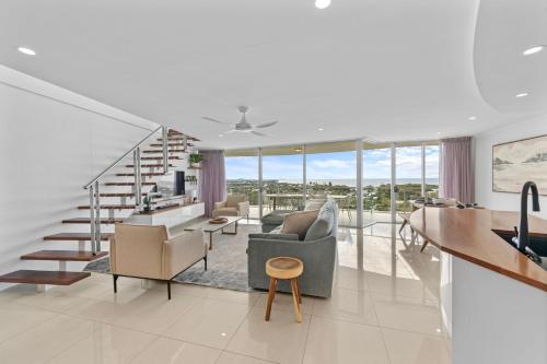 a living room with a staircase and a living room at Beachside Penthouse w Private Rooftop & Oceanviews in Caloundra