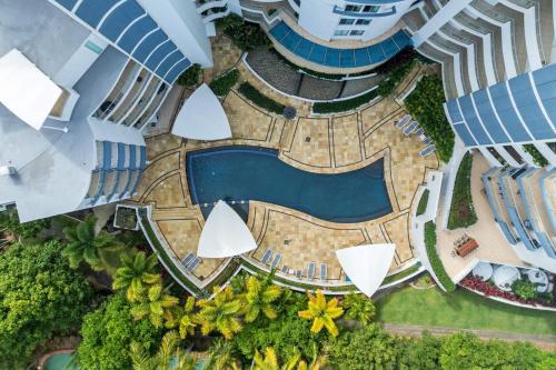an overhead view of a swimming pool in a resort at Beachside Penthouse w Private Rooftop & Oceanviews in Caloundra