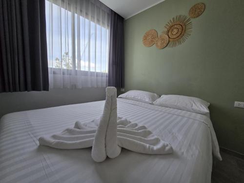 a white bed with a towel on it with a window at Seabreeze Suite 1-Bed T3-637 in Phuket