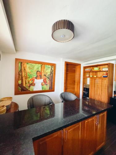 a kitchen with a counter and a painting on the wall at Lux Villa Casa de Campo in La Romana
