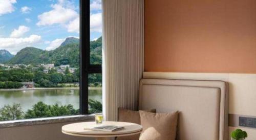 a room with a table and a window with a view at Immersing Hotel Guilin Two Rivers and Four Lakes Dongxi Alley in Guilin