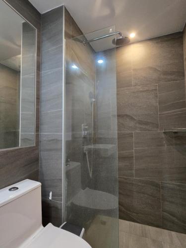 a bathroom with a toilet and a glass shower at Palm Bay Studio T3 -532 in Phuket