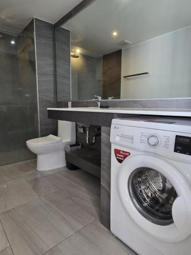 a bathroom with a washing machine and a sink at Skyline Serenity 1Bed T2-721 in Phuket