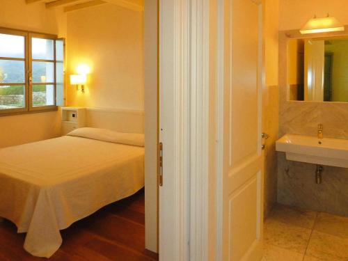 a small bedroom with a bed and a sink at Apartment in Elba with Panoramic Views in Rio nellʼElba
