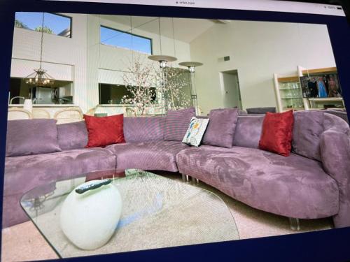 a purple couch in a living room with a glass table at Palm Valley Country Club, Pickleball, Tennis, Gym, Clubhouse, Swimming Pools, Lux, Spac 2 Bdrms Den 2 Ba in Palm Desert