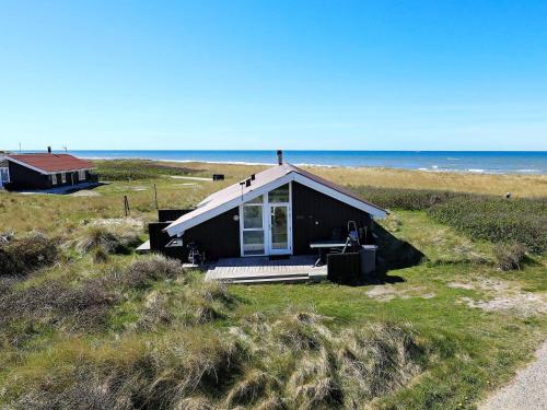 a house on the beach with the ocean in the background at Panoramic Seaside Escape - By Traum Ferienwohnungen in Lønstrup