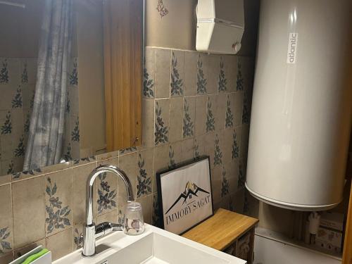 ein Badezimmer mit Waschbecken und Spiegel in der Unterkunft Appartement au pied des pistes à Super Besse - FR-1-814-61 in Besse-et-Saint-Anastaise