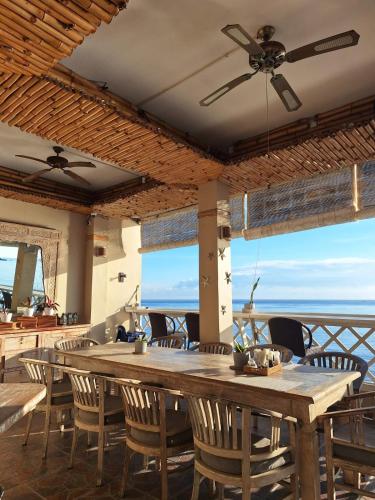 a dining room with a large wooden table and chairs at Tauch Terminal Resort Tulamben & Spa in Tulamben