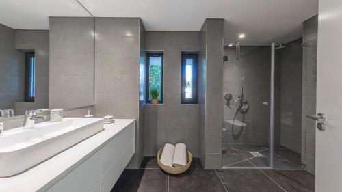 a bathroom with a sink and a shower at NOA Apartment Quinta do Lago in Quinta do Lago