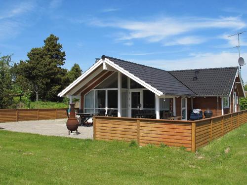 a house with a wooden fence in front of it at 8 person holiday home in Idestrup-By Traum in Marielyst
