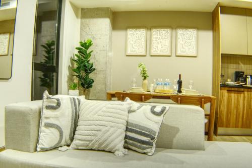 a living room with a couch with two pillows at Expo GDL 2 Min Executive Style and Comfort in Guadalajara