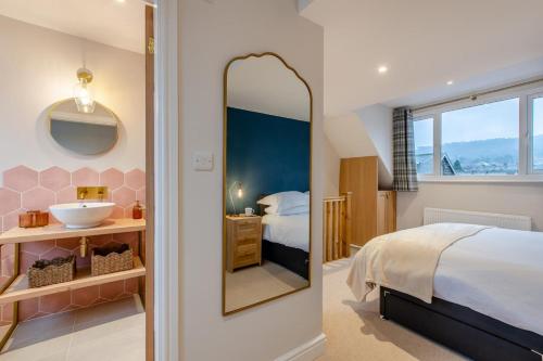 伊尔克利Ilkley Moor View Cottage的带床、水槽和镜子的卧室
