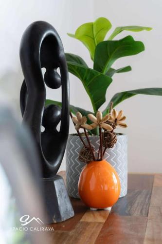 a black statue and an orange vase on a table at Spacio Caliraya Bed & Breakfast in Lumban