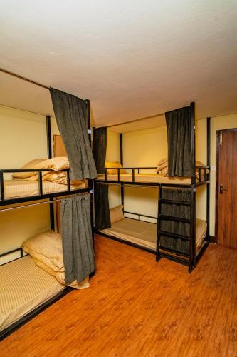 two bunk beds in a room with wooden floors at Kwabahal Garden Hostel in Kathmandu