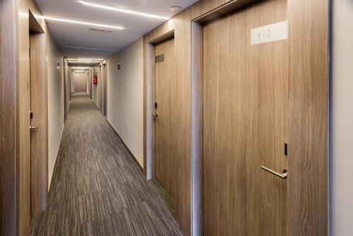 a corridor of a hospital hallway with wooden doors at GHT Sa Riera in Tossa de Mar