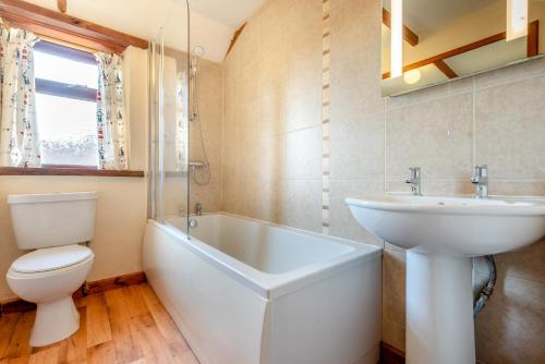 a bathroom with a sink and a tub and a toilet at Mallard Cottage - Padstow in St Merryn