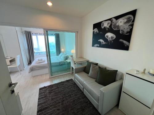 ein Wohnzimmer mit einer Couch und einem Spiegel in der Unterkunft Cozy6 Living in Bangkok 60m to MRT near chatuchank in Ban Bang Khwang