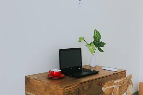a laptop computer sitting on top of a wooden table at Ramady Guesthouse in Tumbak Bayuh
