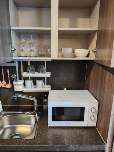 una cocina con fregadero y microondas en Haeundae Elbon The Stay, en Busan