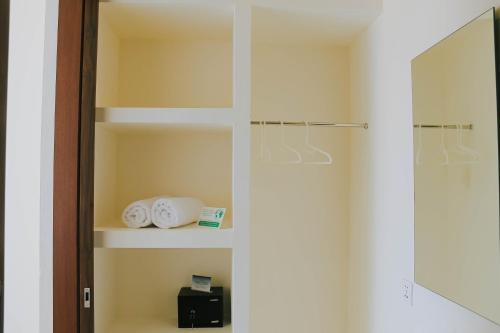 a closet with a glass door with towels and a mirror at Ramady Guesthouse in Tumbak Bayuh