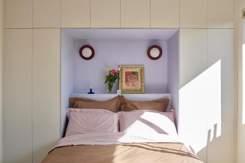 a bedroom with a bed with two clocks on the wall at Designer Bondi apartment - walk to beach! in Sydney