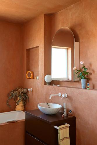 a bathroom with a sink and a mirror and a tub at Designer Bondi apartment - walk to beach! in Sydney