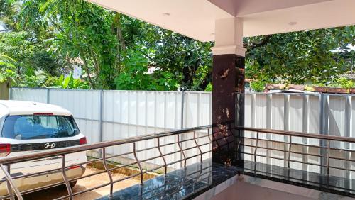 a house with a fence and a car parked at Leland Homestay in Mararikulam