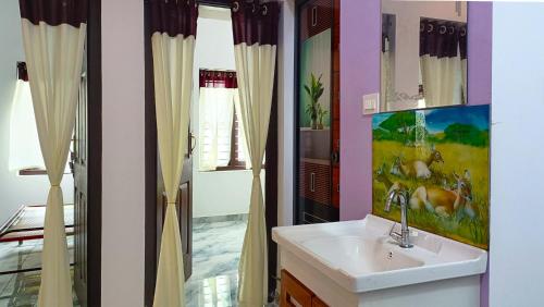 a bathroom with a sink and a mirror at Leland Homestay in Mararikulam