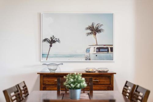 a painting of a van in a dining room with a table at Northwind Beachfront Apartments in Mooloolaba