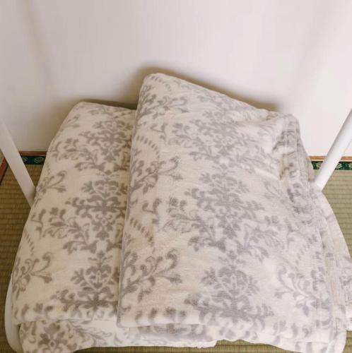 a white blanket sitting on top of a chair at NU1 Guesthouse NUI okhotsk女満別 in Abashiri